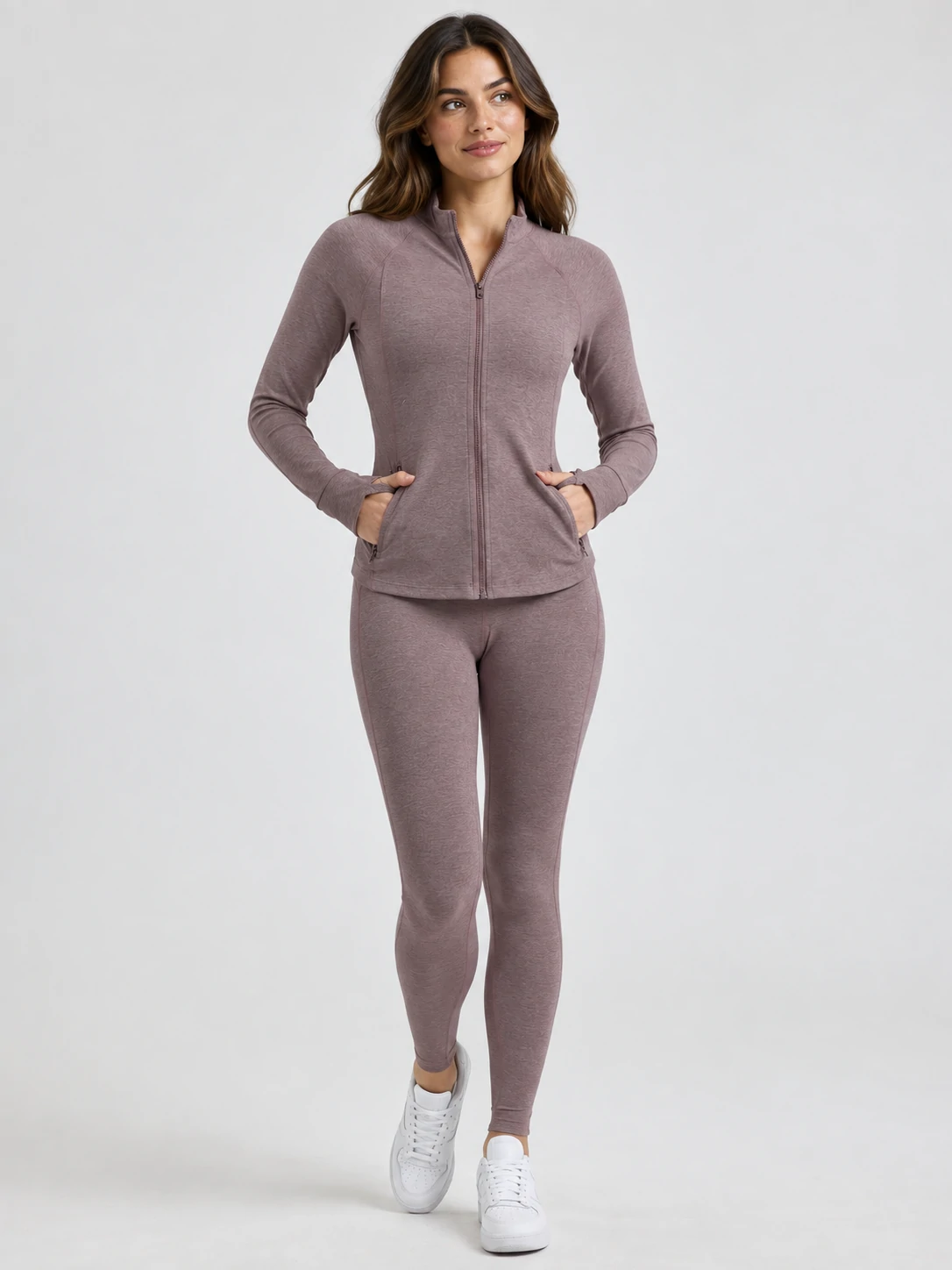 Female model wearing a mauve zip-up activewear jacket with matching leggings for women’s custom gymwear and training wear