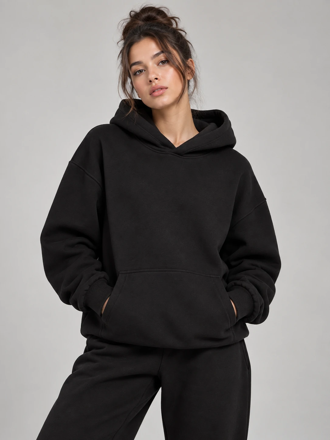 Female model wearing an oversized black pullover hoodie with matching jogger pants for women’s custom activewear and athleisure wear