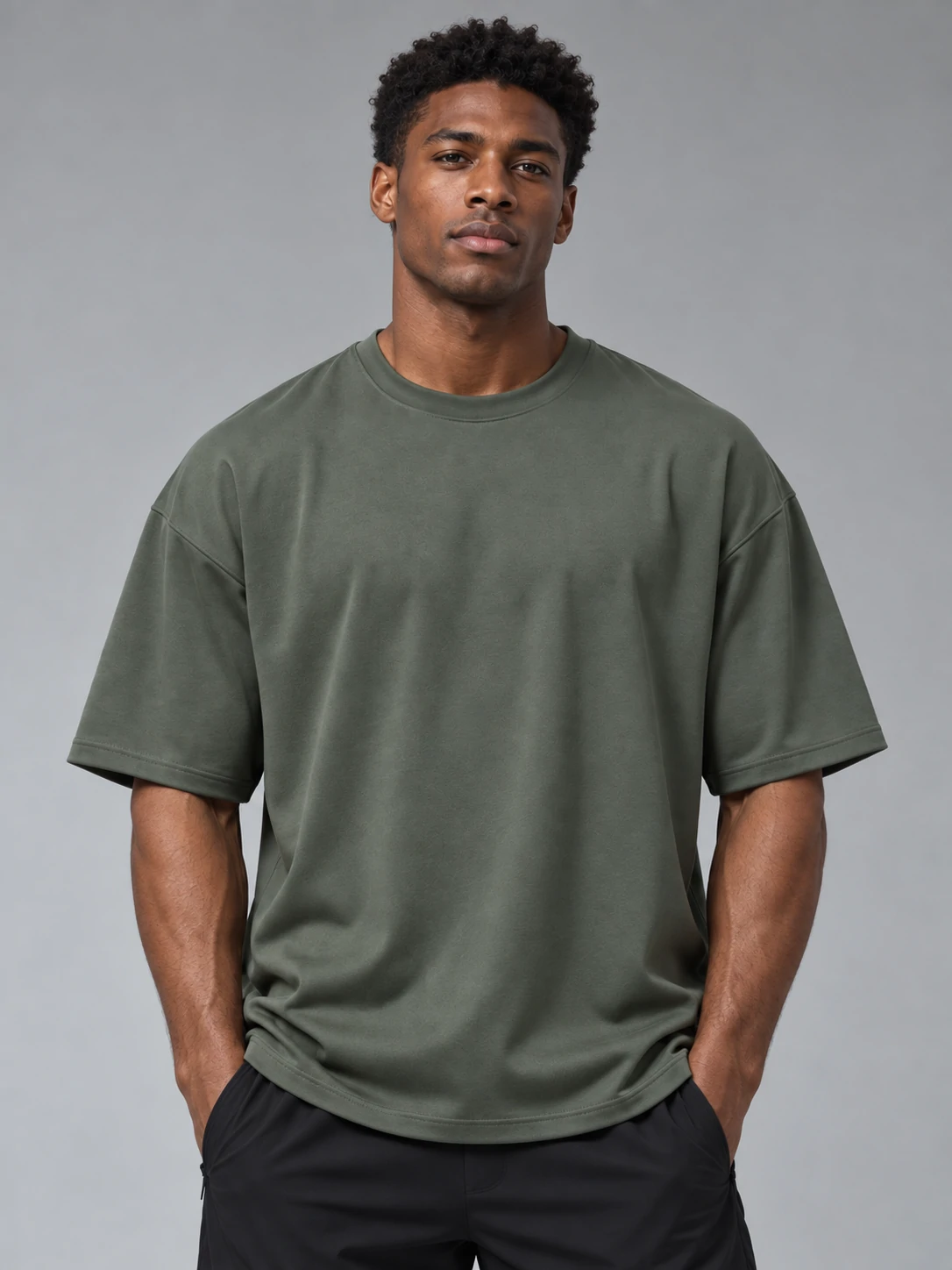 Male fitness model wearing an olive oversized gym T-shirt with black training shorts for men’s custom activewear