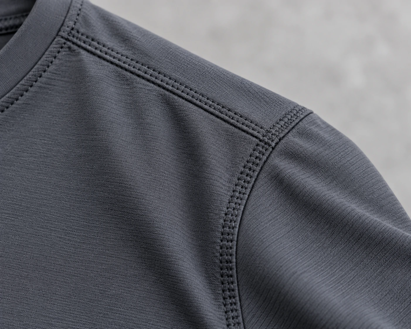 Close-up of a performance gym T-shirt showing reinforced flatlock shoulder seams and technical stretch fabric for custom activewear production