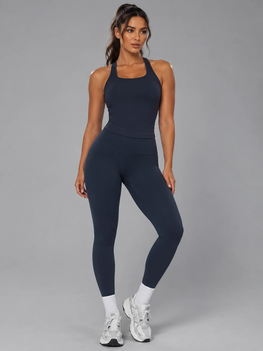Female fitness model wearing a navy activewear tank top and high-waisted leggings for women’s gym and training wear