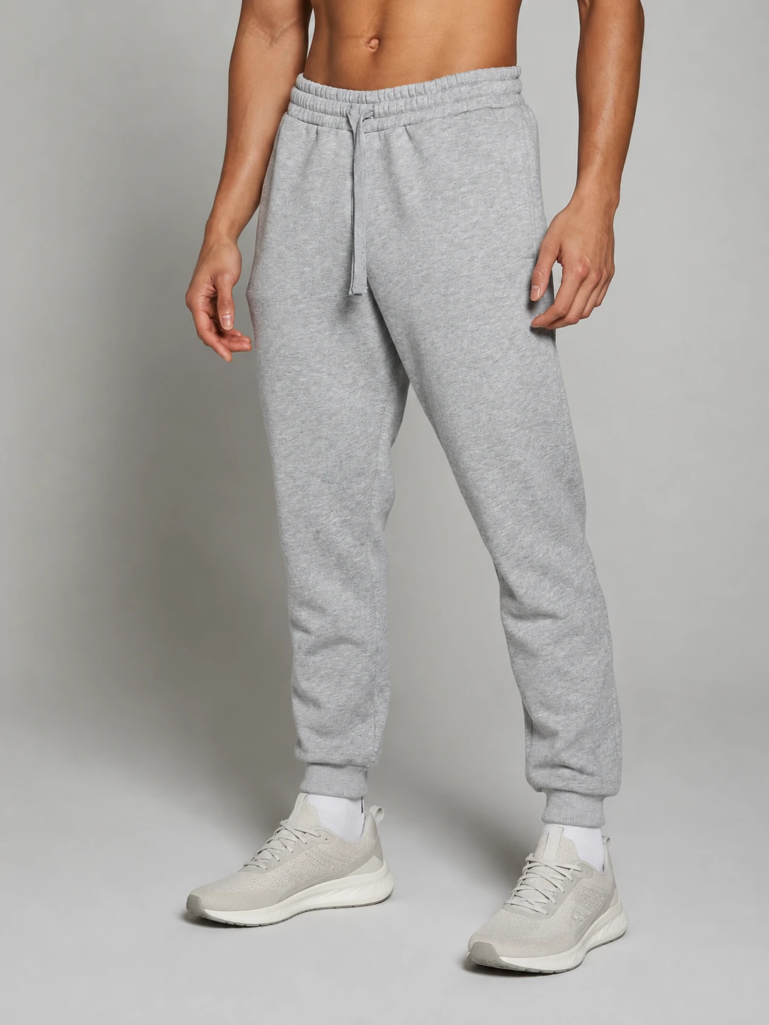 Male fitness model wearing light gray drawstring jogger pants for men’s custom gymwear and activewear