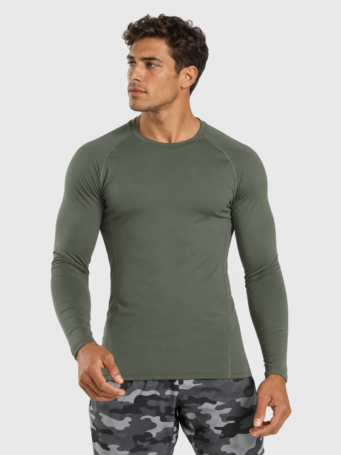 Male fitness model wearing an olive green long sleeve compression shirt for men’s gym training and custom activewear