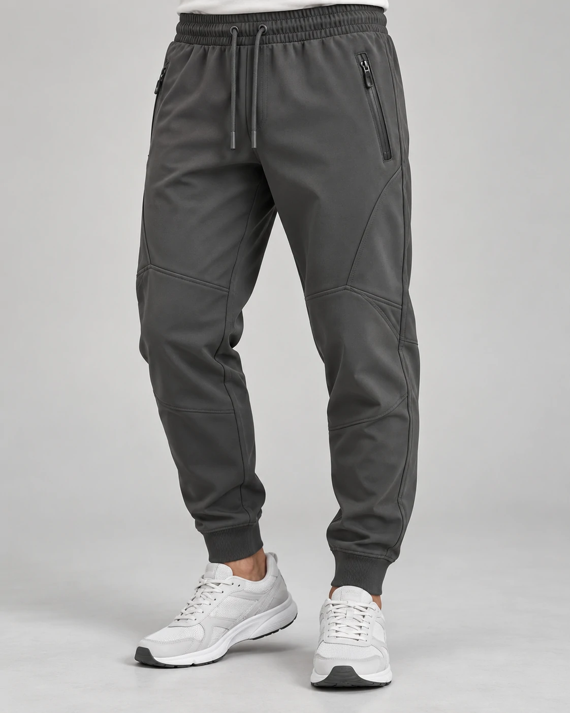 Men's charcoal technical joggers featuring elastic waistband, zip pockets and panel seams